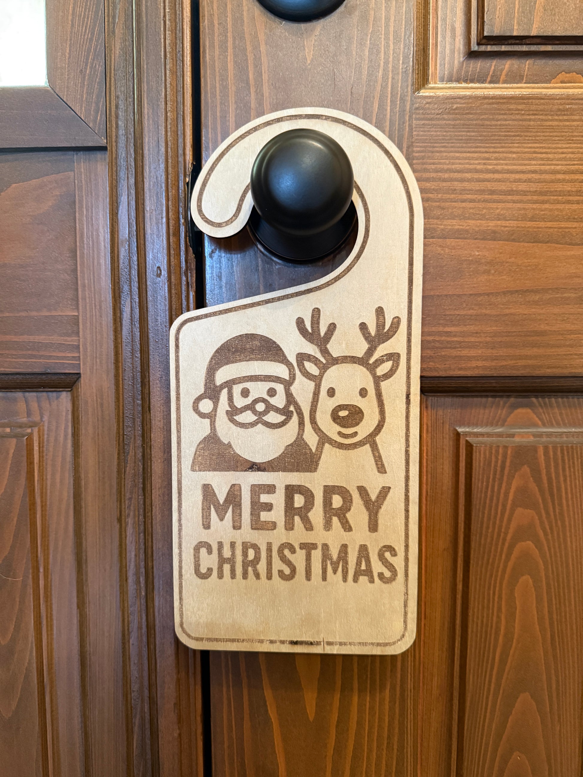 Wooden door hanger with Christmas design and 'Merry Christmas' text on a wooden door.